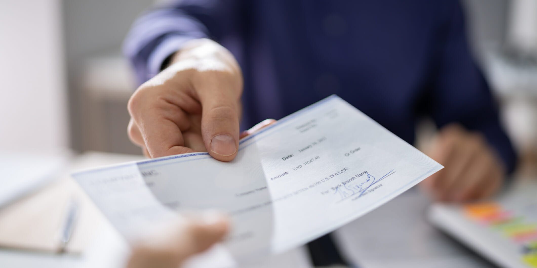 Businessperson Hands Giving Cheque To Other Person